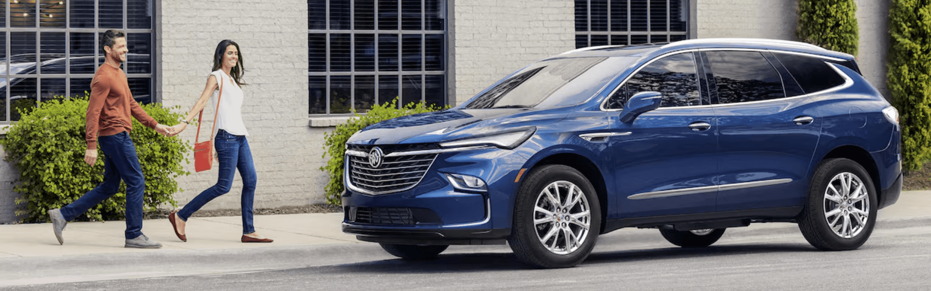 2024 Buick Enclave in blue parking couple getting to the vehicle