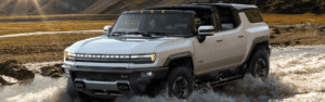 2024 GMC HUMMER EV SUV in white running thourgh a creek