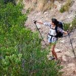 A couple walking along a hiking trail along a mountain range