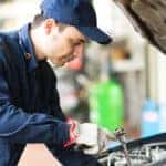 Portrait of an auto mechanicin front of a car in his garage