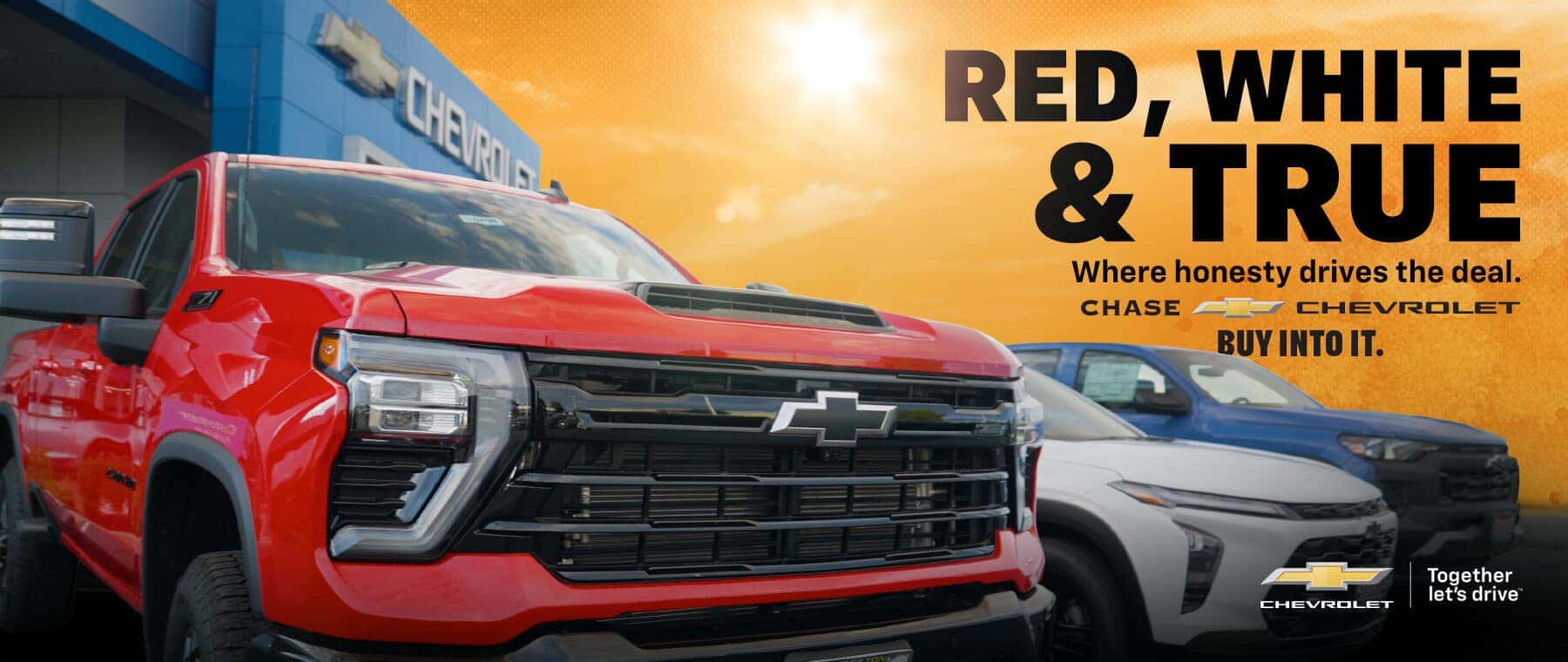 Red Chevrolet Silverado HD pickup parked in front of Chase Chevrolet with white SUV and blue truck in the background beneath a "Red, White & True" promotional banner.