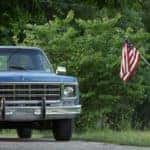 A vintage chevy truck in front f US flag