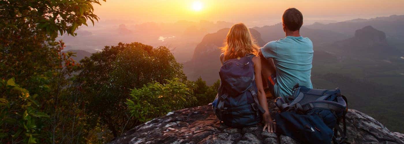 couple on cliff watching the sunset