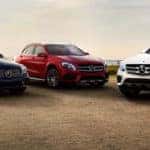 Three Mercedes-Benz vehicles parked angled towards one another in the desert