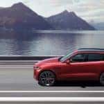 The 2021 Jaguar F-Pace driving in front of water and mountains.