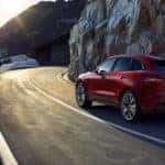 A red 2021 Jaguar f-Pace driving down a road.