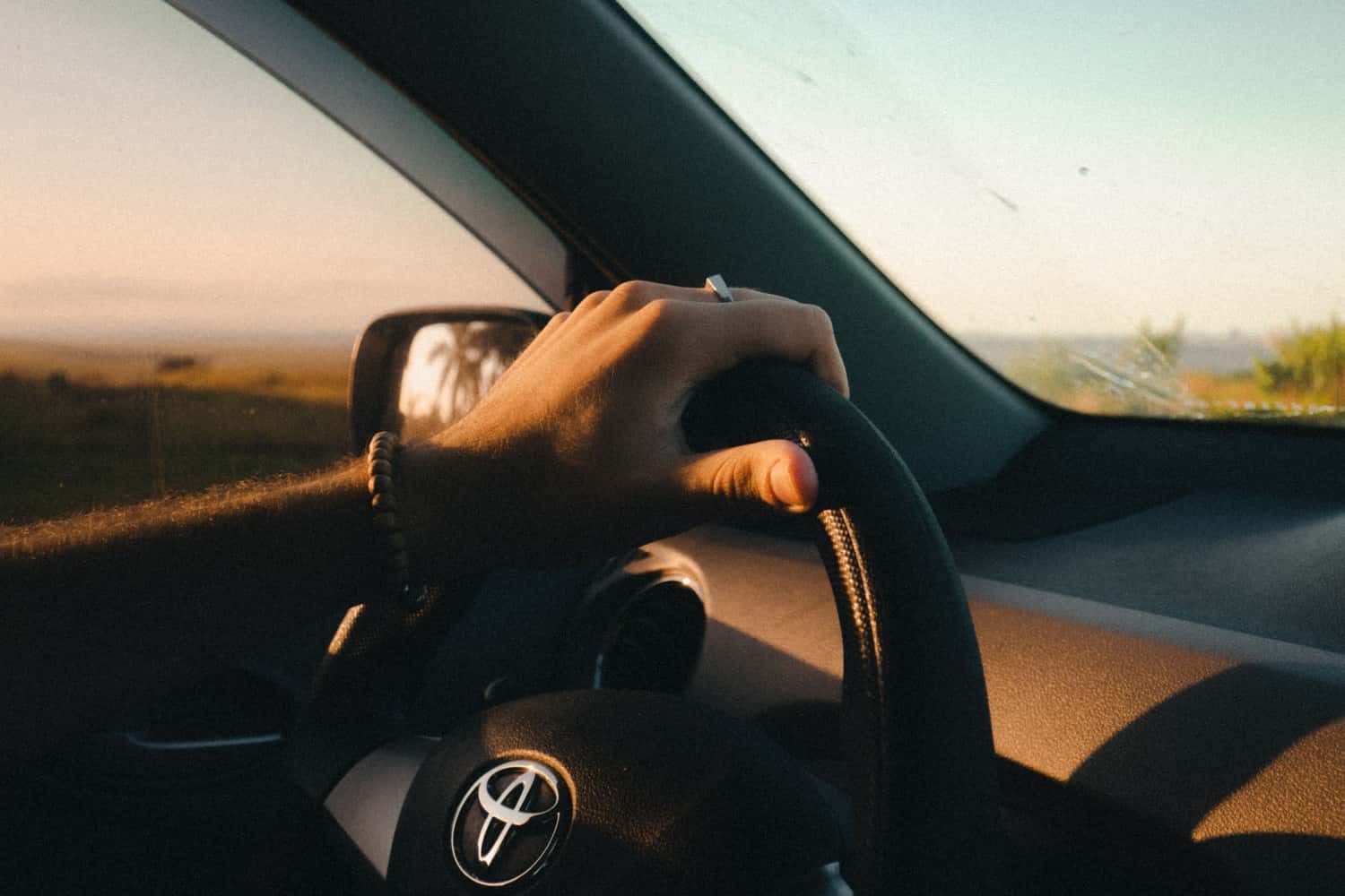Driver holding steering wheel while driving vehicle on highway