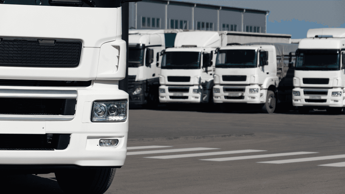 A group of semi-trucks parked outside of a vehicle center