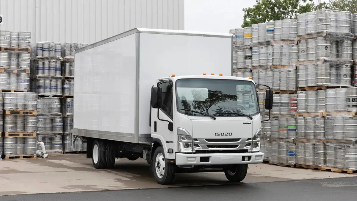 An Isuzu NPR truck parked at a loading area
