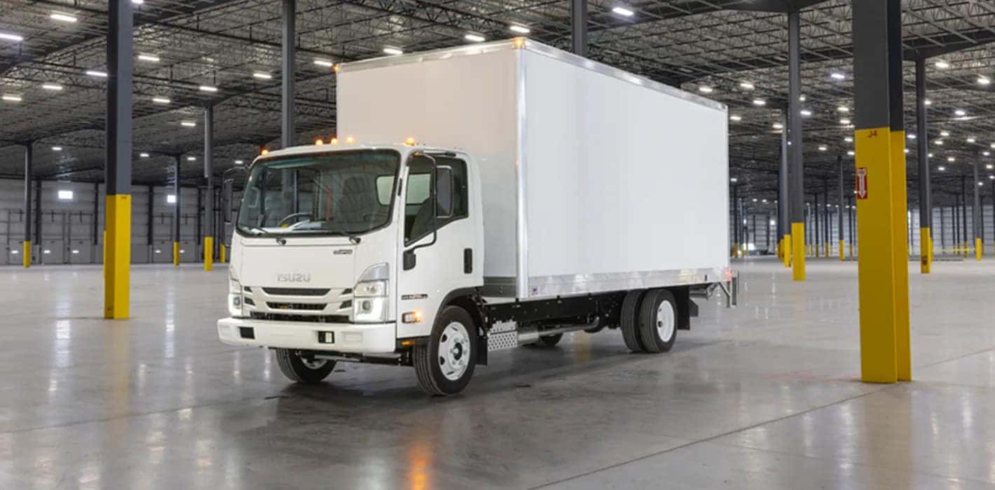 A white Isuzu truck in an empty warehouse