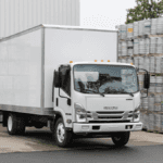 An Isuzu N-Series truck parked near a series of metal series
