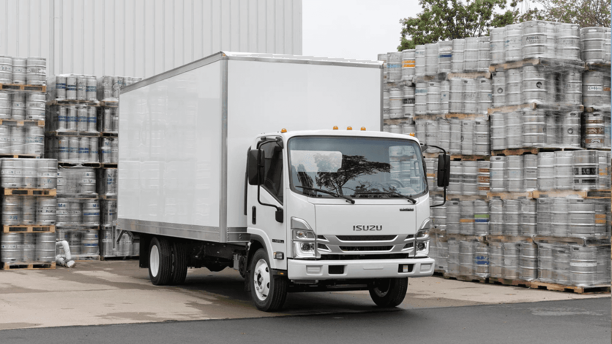 An Isuzu N-Series truck parked near a series of metal series