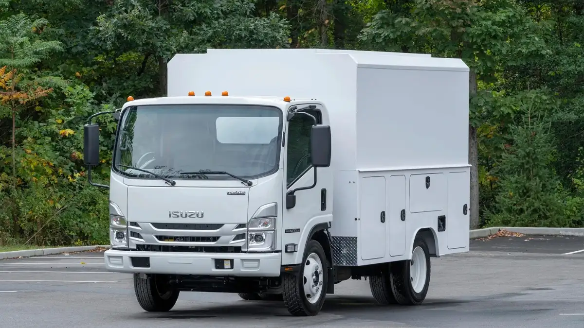 A white Isuzu N-Series box truck in a parking lot