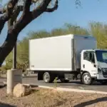 An Isuzu diesel truck driving through a parking lot at a park