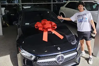 Happy young man who just purchased black C-Class