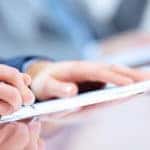 Person signing financial documents at a dealership