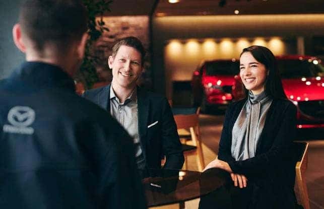 A man and a woman are financing a Mazda car near Gastonia & Charlotte, NC