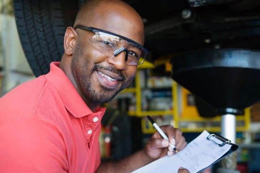 automotive mechanic inspects vehicle