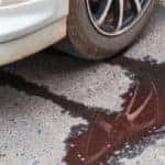 Car leaking water onto the ground near the front tire