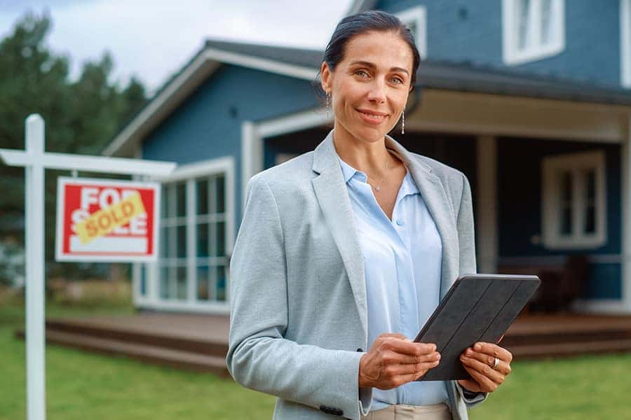 real estate agent standing outside a sold house
