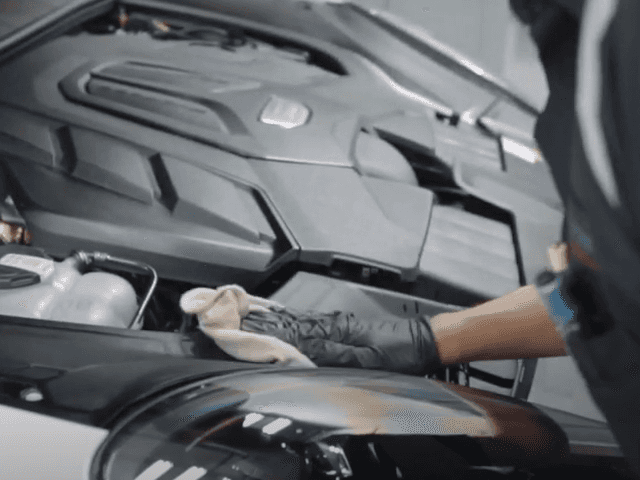 Porsche Pre-Paid Maintenance man cleaning engine
