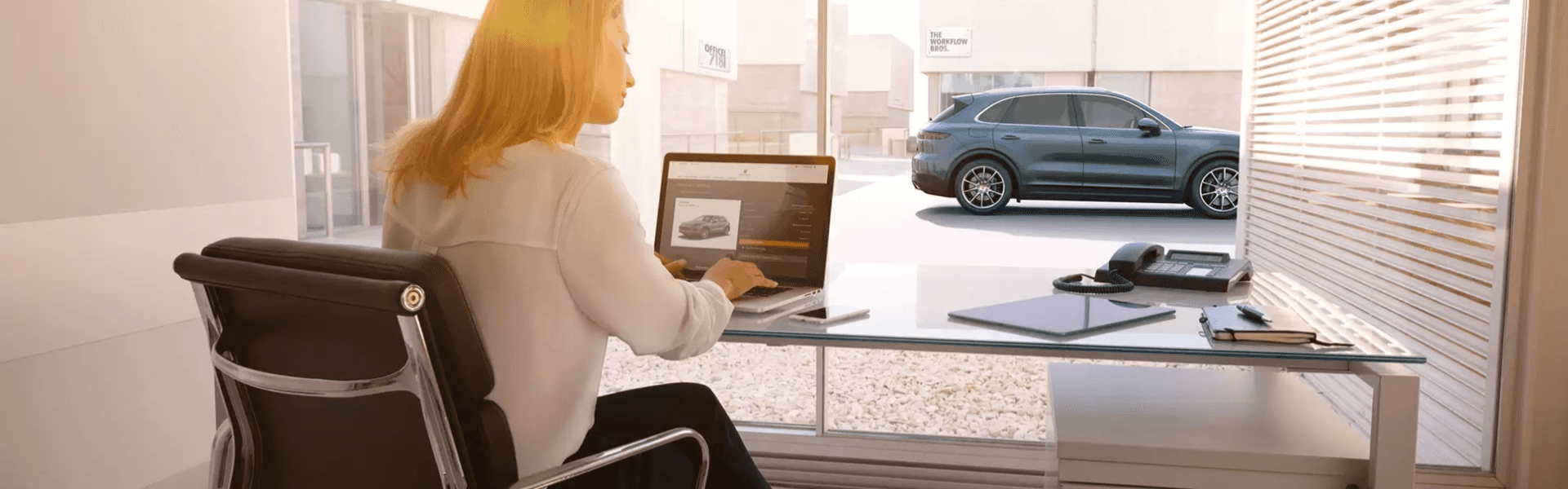 Customer using a laptop to buy a Porsche from home