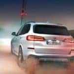 back of 2019 bmw x5 driving on dirt road at night