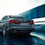 2019 bmw 5 series sedan driving on highway ramp