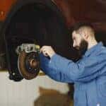 Man checking brakes on a car