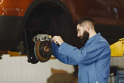 Man checking brakes on a car