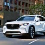 2025 Mazda CX-90 cruising down a busy city road
