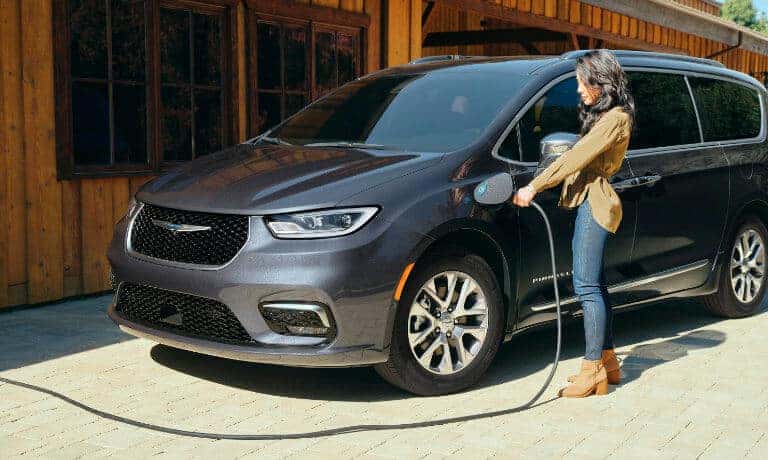 Woman plugging in 2022 Chrysler Pacifica Hybrid