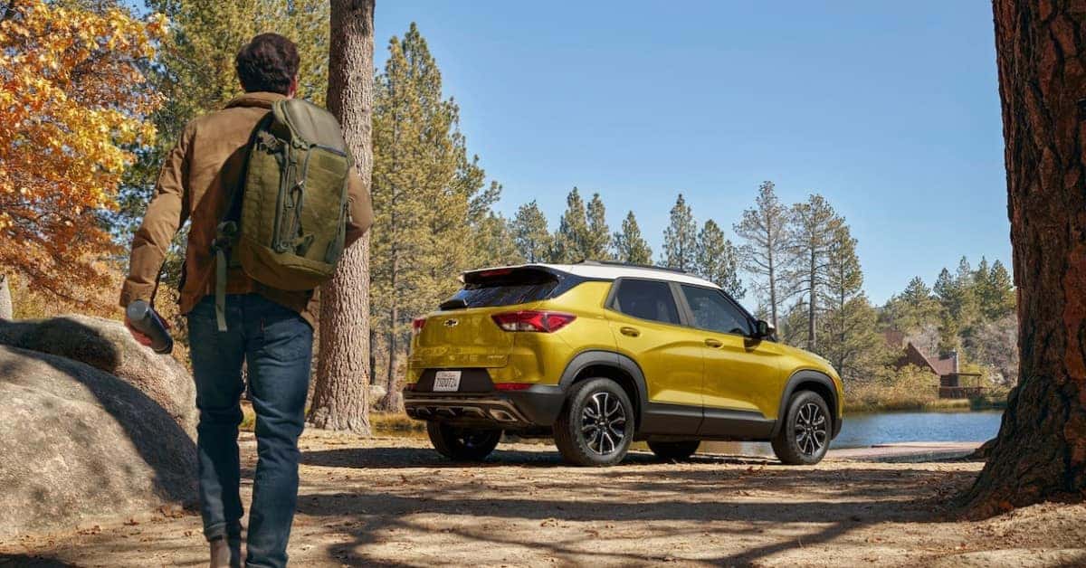 2023 Chevrolet Trailblazer Next To A Lake in the Woods With A Camper Walking