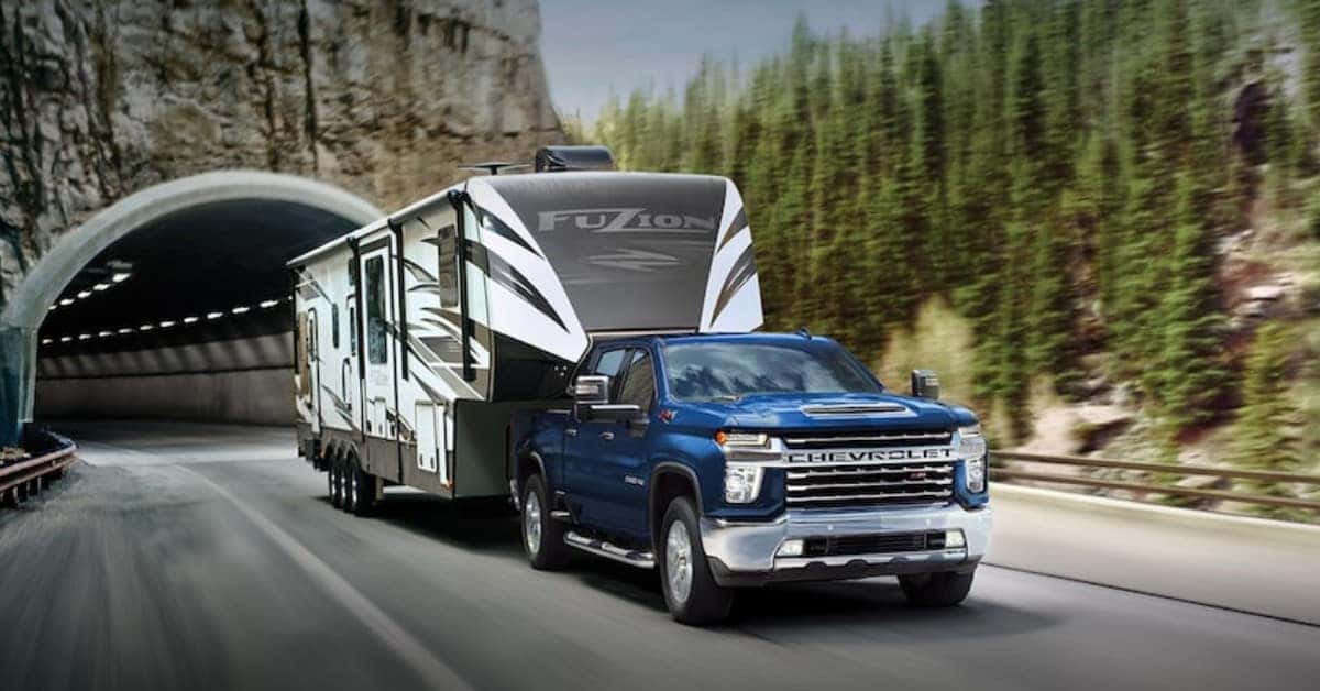 Blue 2023 Chevrolet Silverado 2500 HD Hauling A 5th-Wheel Camper
