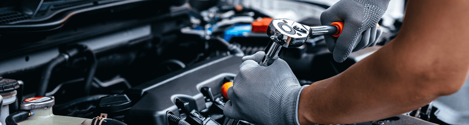 A service technician works on a car engine, like the service technicians at Spartanburg Honda.