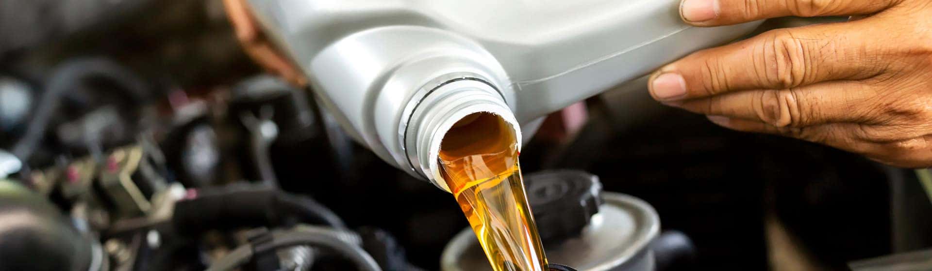 Close-up of a service technician performing an oil change.