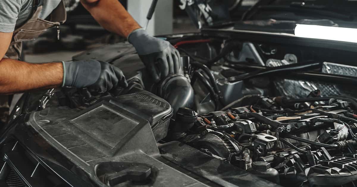 A technician works on a car engine