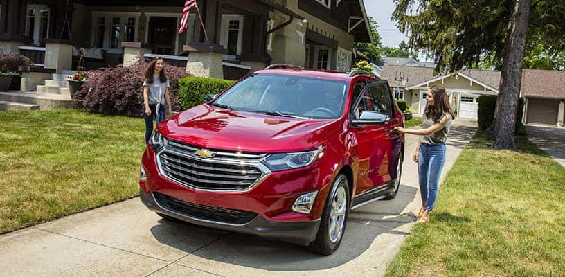 Two Teenagers Approaching a Red Chevrolet Vehicle