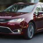 A dark red 2017 Chrysler Pacifica driving on a suburban street near Colorado Springs.