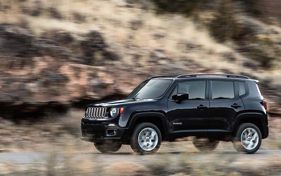 A black 2015 Jeep Renegade is driving on a desert road.
