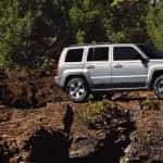 A silver 2016 Jeep Patriot parked on a rocky cliff