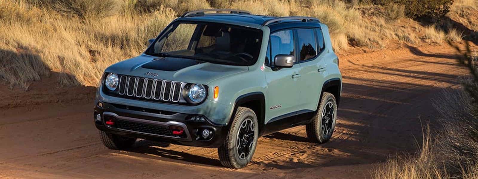 Green 2016 Jeep Renegade driving off road in savannah
