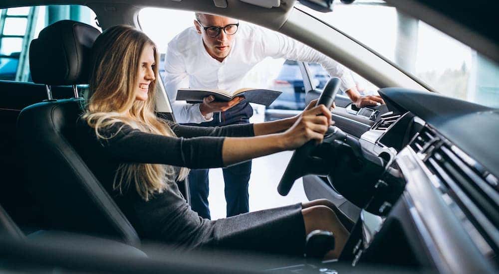 A smiling person is shown before a test drive at one of the areas top used car dealerships.