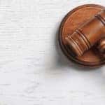 Brown gavel and wooden circle sitting on a grey table