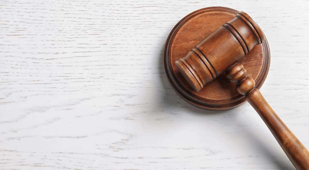 Brown gavel and wooden circle sitting on a grey table