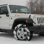 A white 2010 Jeep Wrangler Islander in snowy field
