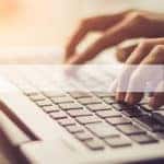 Partially transparent search bar over a picture of hands on a laptop keyboard
