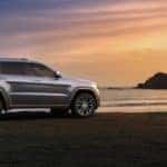 Silver 2018 Jeep Grand Cherokee at beach at sunset