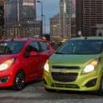 Red and Green 2015 Chevy Spark in city