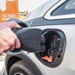 A hand plugs in a Chevy Bolt EV